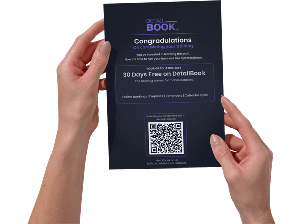 Hands holding the DetailBook graduate flyer